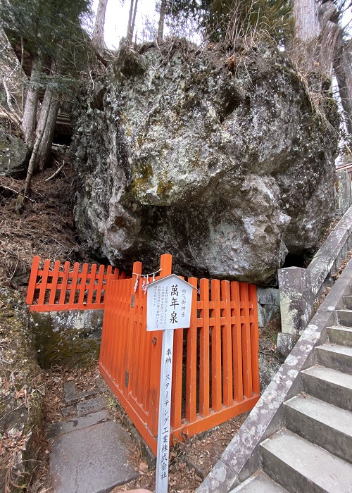 赤い柵で囲まれている萬年泉