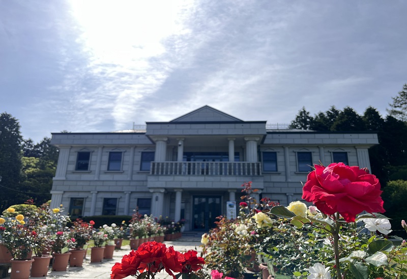 西洋風建築の湖畔展望館と赤いバラ