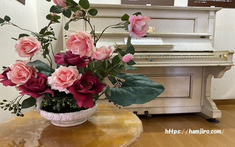 造花のバラと白いピアノ