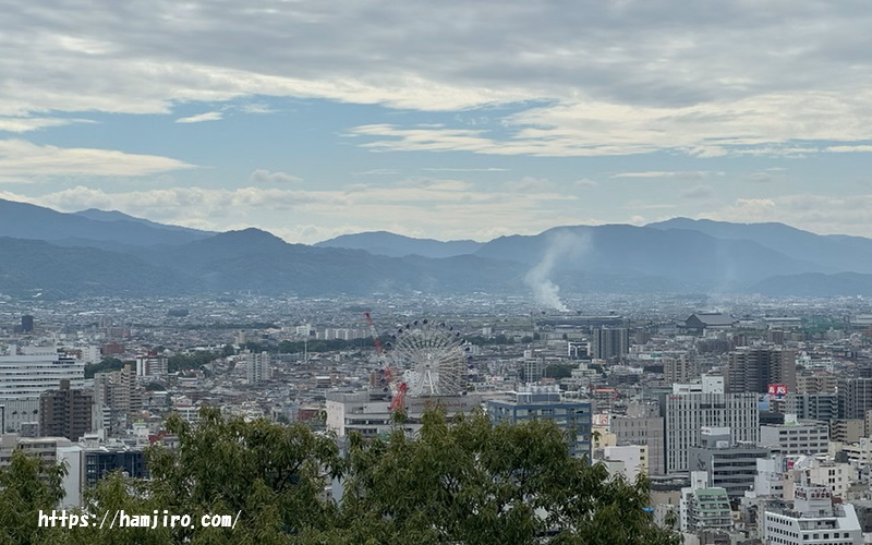 手前にビル群遠くには山々がが見え渡せる景観