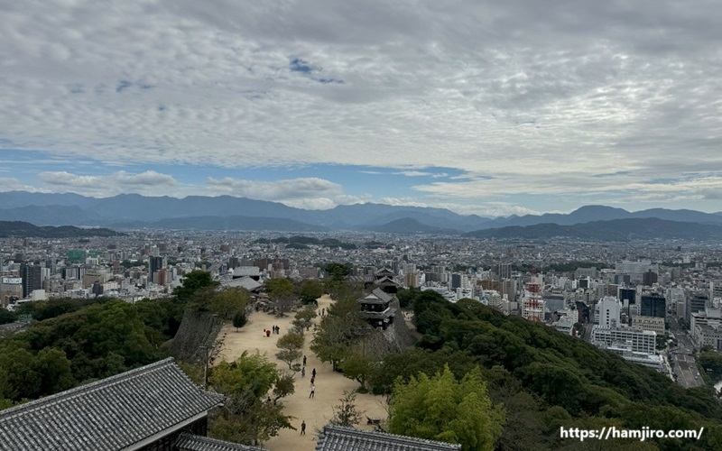 俯瞰した位置から本丸広場と奥には松山市都市