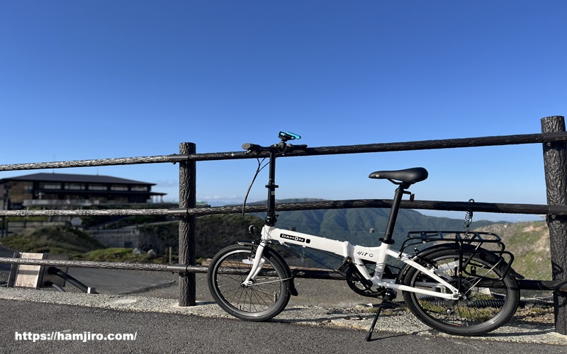 大涌谷を背景に白い折りたたみ自転車