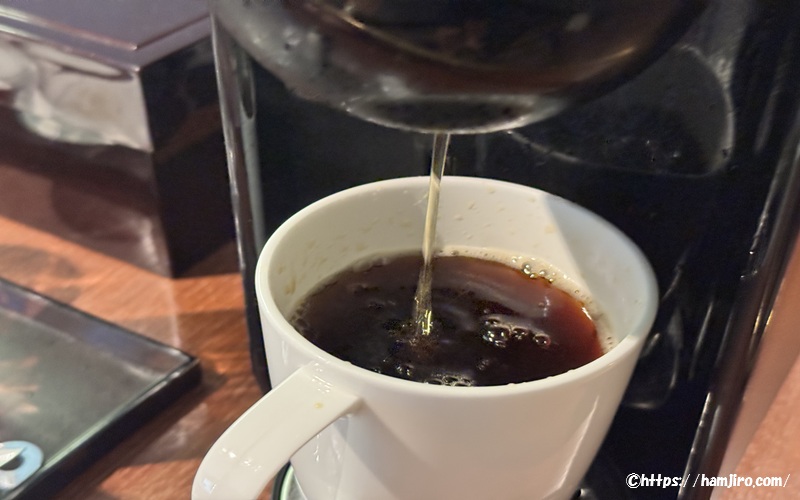 コーヒーマシンからコーヒーが注がれる様子